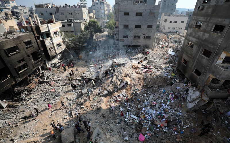 Palestinians return to a destroyed Gaza. Image via FMT.